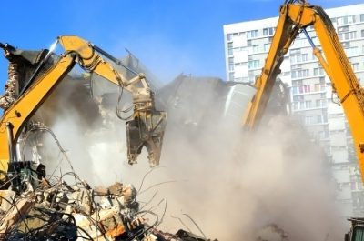 two excavators demolishing a building