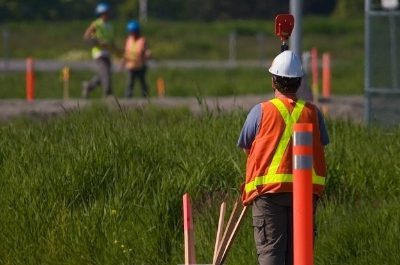 a quantity surveyor at work with two assistants